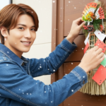 玄関に正月飾りつけする男性